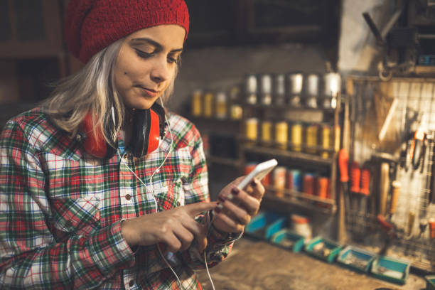 istock Young lady in the work shop using smartphone 915718792