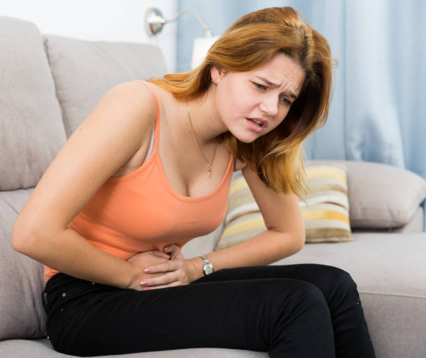 istock female holding hands on the illness stomache 915721452