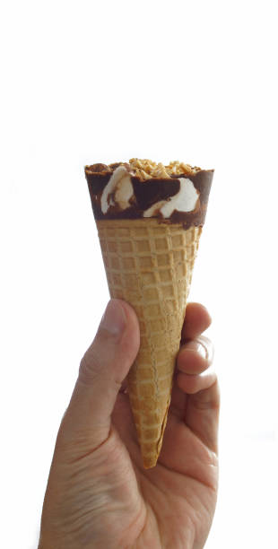 istock Man's hand holding a chocolate covered vanilla ice cream cone with peanut 915721996