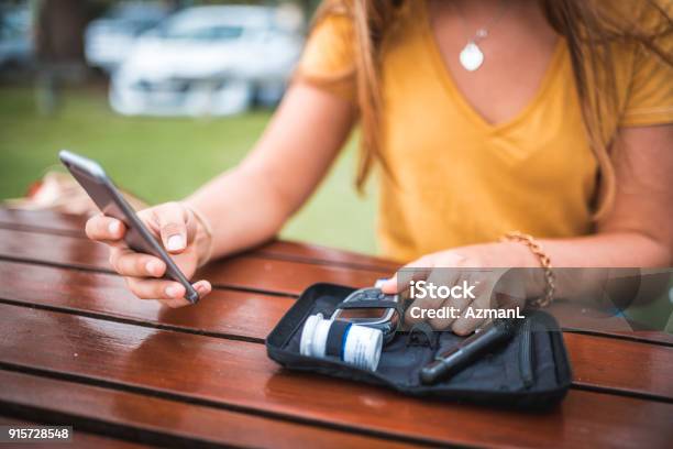 Photo libre de droit de Jeune Femme Mesurant Le Niveau De Sucre Dans Le Sang Et Lutilisation De Téléphone Portable banque d'images et plus d'images libres de droit de Diabète