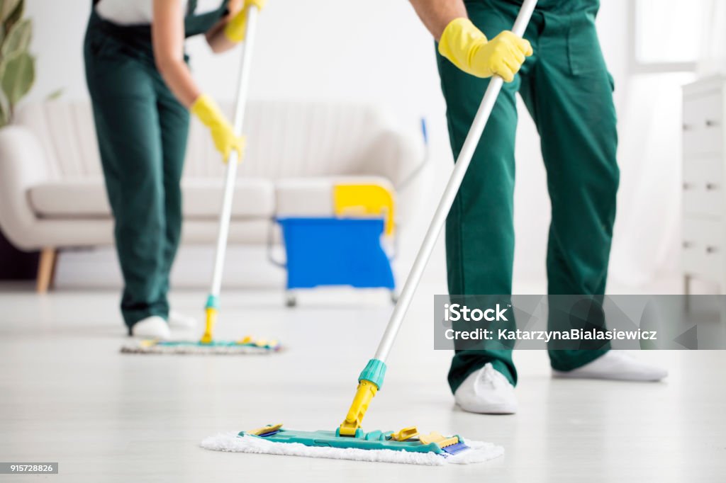 床を拭いて清掃チーム - きれいにするのロイヤリティフリーストックフォト