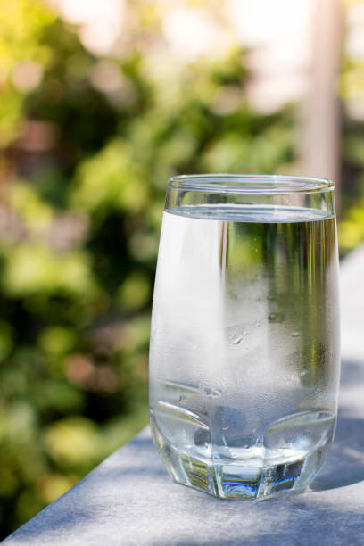 istock one water glass with blur green background 915734898
