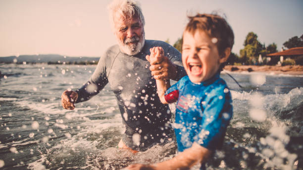 Summer fun Photo of a little boy and his grandfather spending summer afternoon  bathing and swimming in a sea water sports or fitness photos stock pictures, royalty-free photos & images