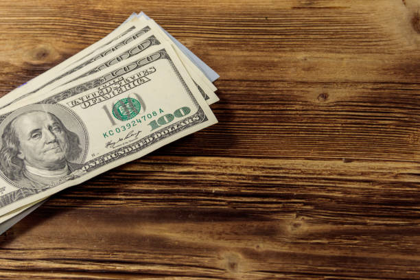 istock Stack of one hundred dollars bills on wooden desk 915748198