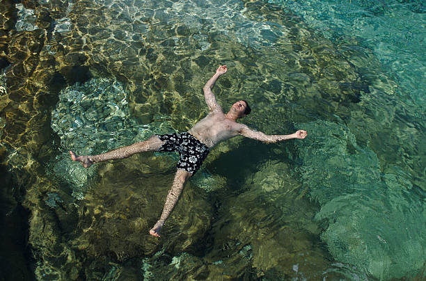 istock Guy Floats Spreadeagle in Rippling Waters 91575280