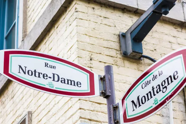 Closeup of lower old town street signs in Quebec City, Canada called Rue Notre-Dame and Cote de la Montagne