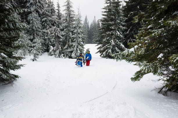 istock Two snowboarders rises up the mountain slope 915759816