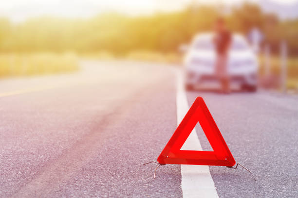 istock Emergency stop sign and broken silver car on the road 915760924