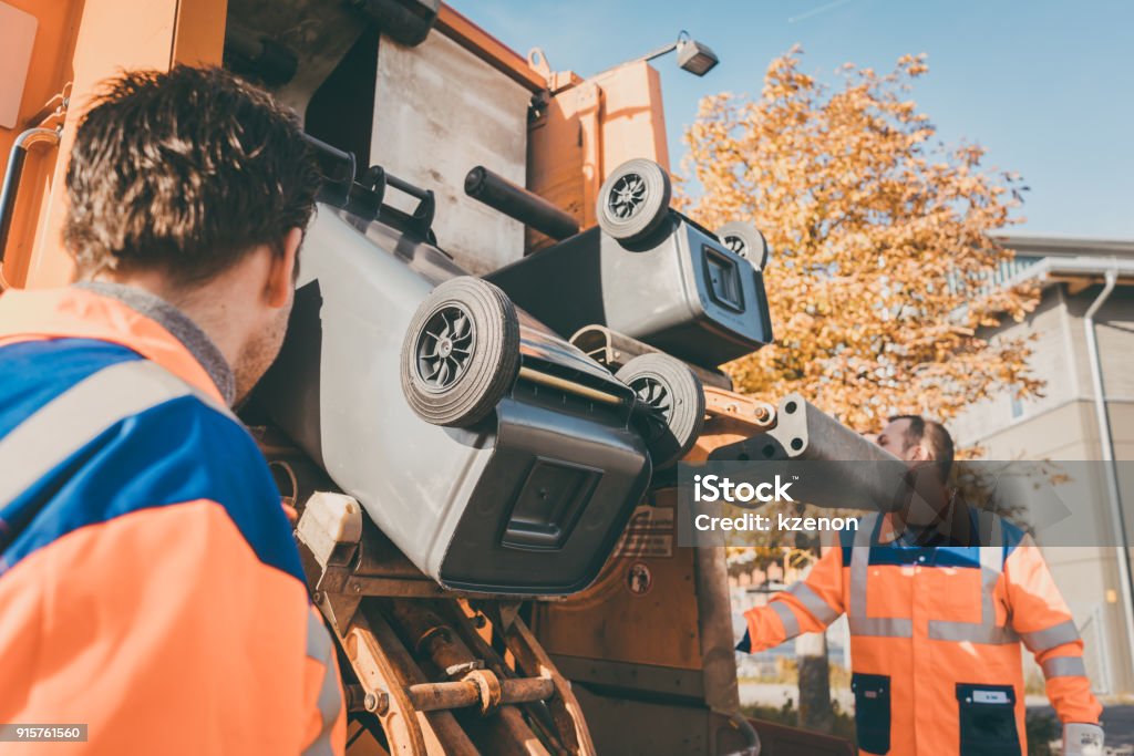 Worker emptying dustbin into waste vehicle Garbage removal Worker emptying dustbin into waste vehicle Garbage Truck Stock Photo