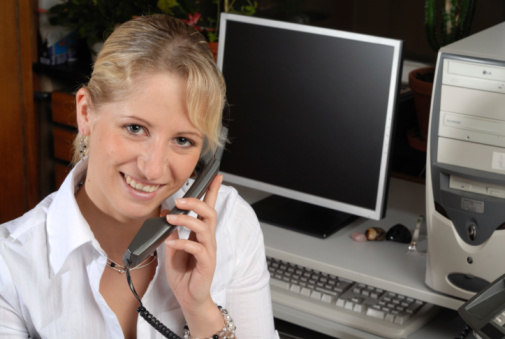 Young blonde girl working in office