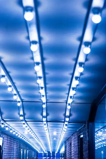 Blue illuminated alley with lights in evening passage in downtown Georgetown neighborhood and brick buildings at night