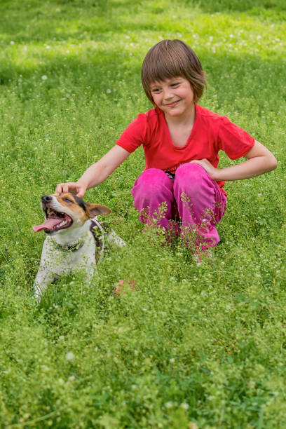 istock child and dog in grass 915769312