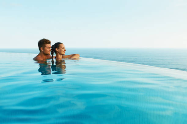 ロマンチックな夏休みの高級リゾート プールに愛のカップル - vacations infinity pool relaxation swimming pool ストックフォトと画像