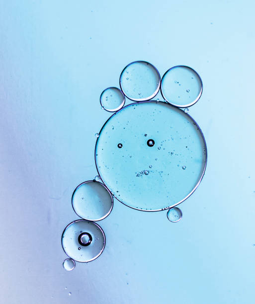 gotas de óleo brilhante e original, círculos na superfície da água. - liquid plasma water abstract - fotografias e filmes do acervo