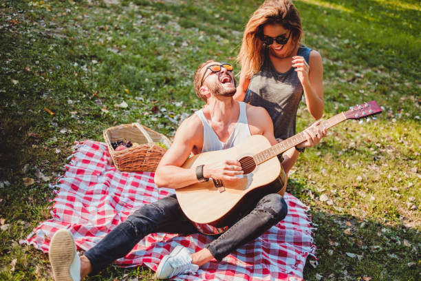 istock Man singing to his girlfriend on a picnic 915775736