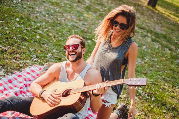 istock Couple having fun with guitar on a picnic 915775752
