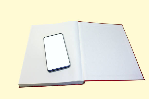 istock Open paper book with smart phone on isolated background 915779782