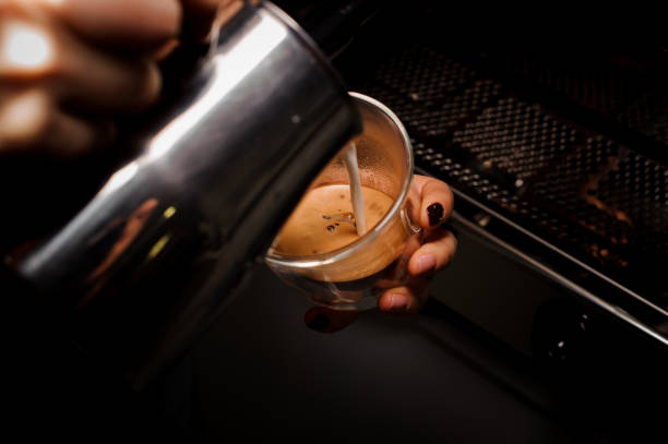 istock Female hands pouring milk from pitcher into the coffee cup 915783392