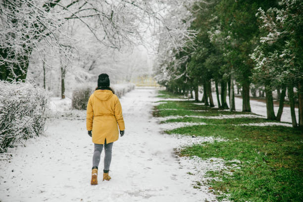 istock woman walk by park where winter meet spring 915783648