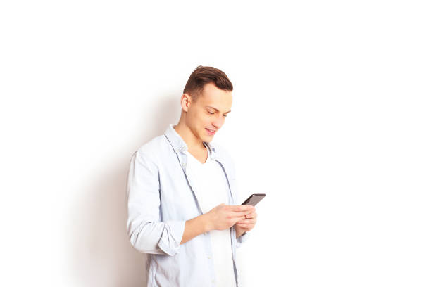 istock Young man checking mobile phone, reading a message. Technology & relationship concept. Modern romance troubles. Male & female online dating app. Touch screen, chatting, swiping, browsing, surfing. 915786110