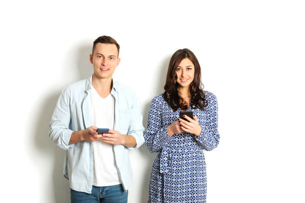 istock Young couple checking mobile phone, reading a message. Technology & relationship concept. Modern romance troubles. Male & female online dating app. Touch screen, chatting, swiping, browsing, surfing. 915786366