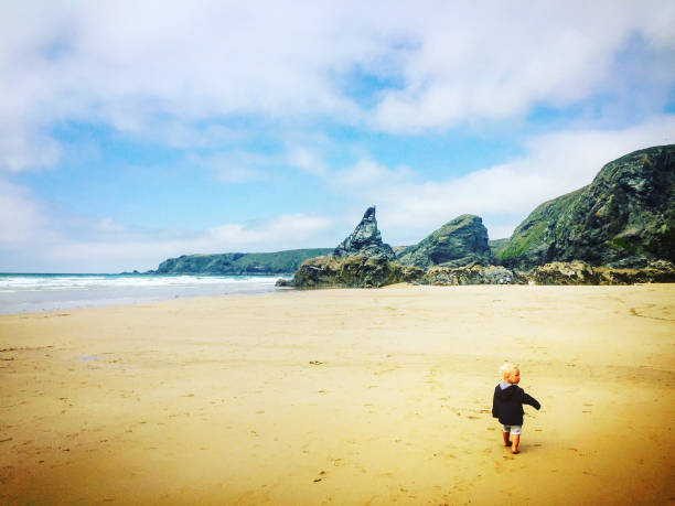 Little boy running on empty beach England, Cornwall England