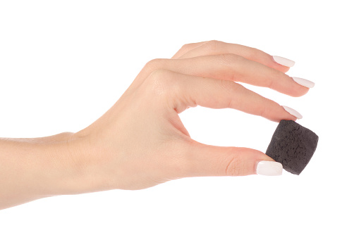 A piece of coal in hand on a white background isolation