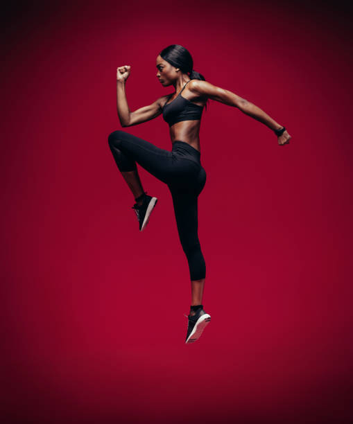 istock African female athlete jumping and stretching 915789258