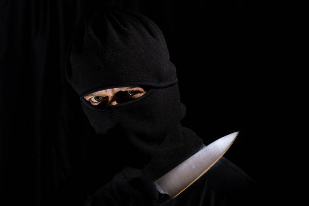 istock Man with a mask and knife 915791362