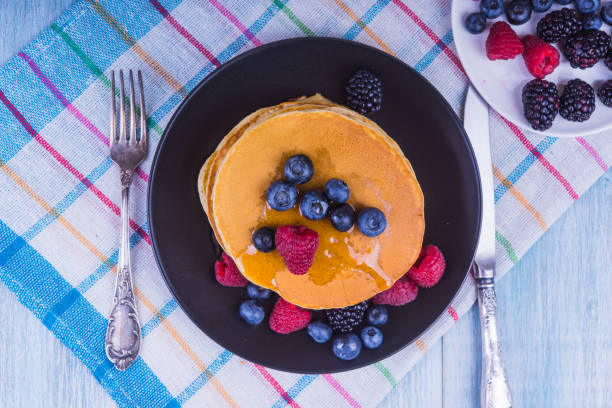 istock rural breakfast - tea and pancakes with berries and honey - top view 915795302