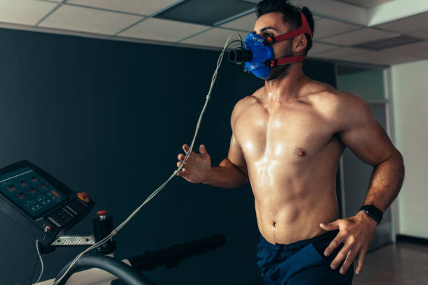 istock Fit and muscular athlete with mask running on treadmill 915796492