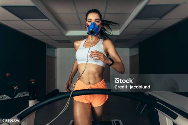 Sportswoman With Mask Running On Treadmill Stock Photo - Download Image Now - Treadmill, Running, Athlete