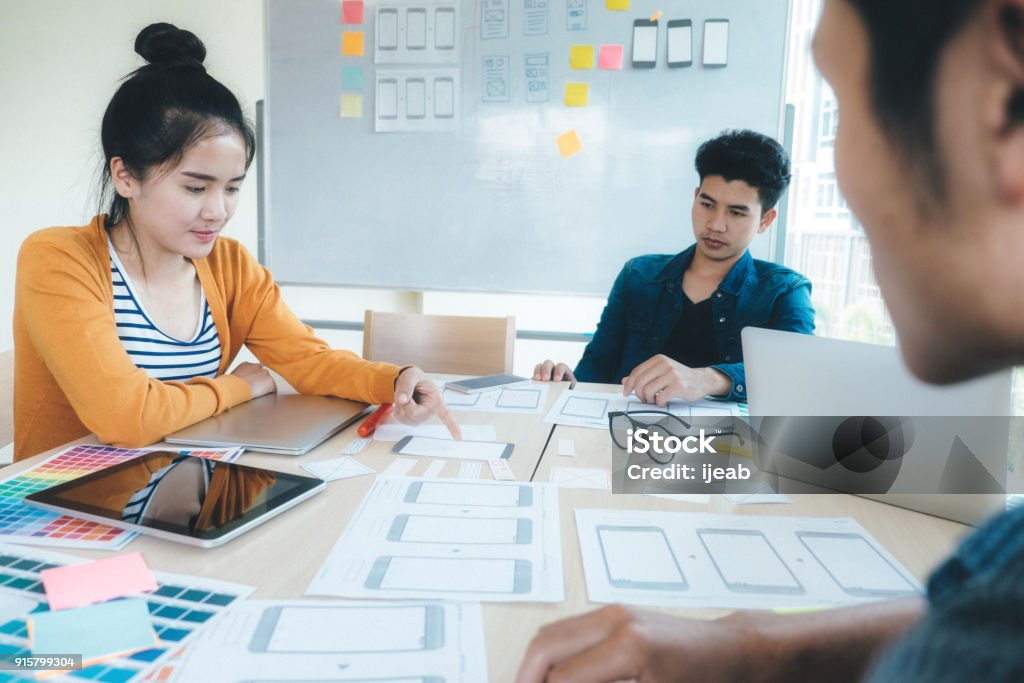 Programmer and Web designer, UX UI meeting for planing mobile application. Programmer and Web designer, UX UI designer planning application for mobile phone. Design Stock Photo