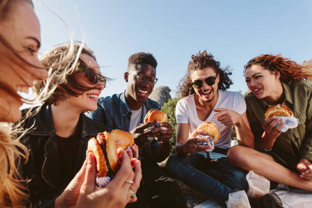 jóvenes tener un picnic en la montaña - hamburguesa alimento fotografías e imágenes de stock