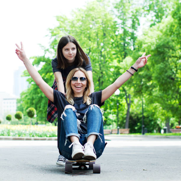 istock Mother and daughter skateboarding 915809734