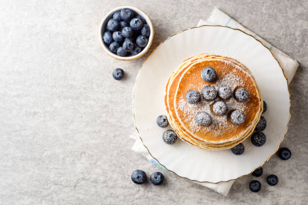 istock Pancakes with blueberries and sugar on grey stone background. 915816562