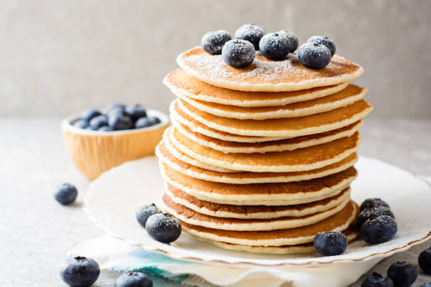 istock Pancakes with blueberries and sugar on grey stone background. 915818682