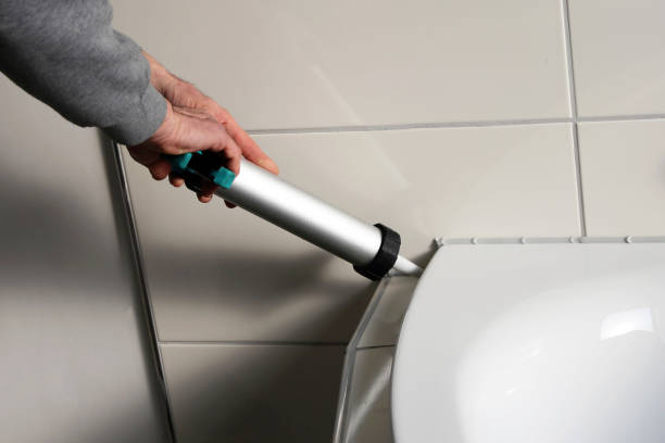istock Man sealing a bath or basin with silicone 915819738