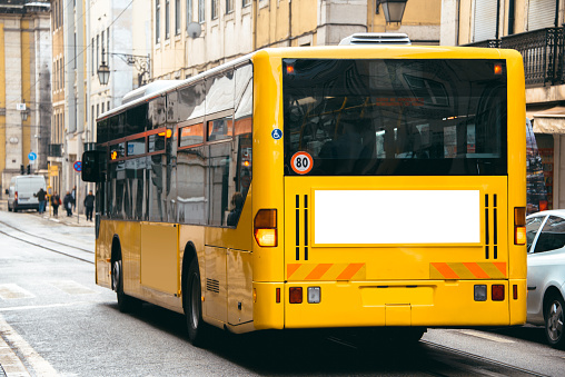 A yellow bus with a blank billboard