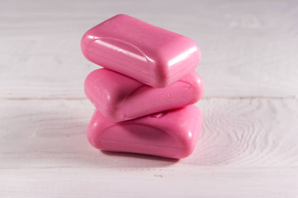 istock Stack of three pink soap on white wooden background 915822080