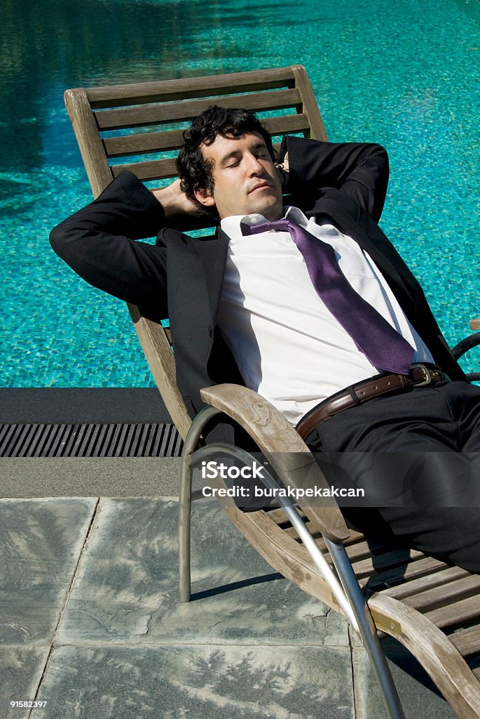 Empresário deitado para baixo perto da piscina, Zekeriyaköy, Istambul, Turquia - Foto de stock de 25-30 Anos royalty-free