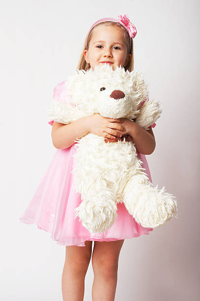 istock young girl in pink on light background with teddy bear 91582615