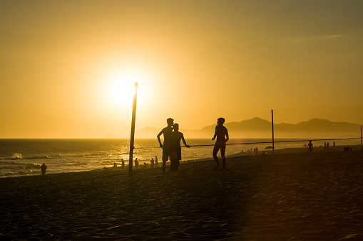 silhouette of men talking at the beach during sunset in barra da Tijuca beach, Rio de Janeiro
