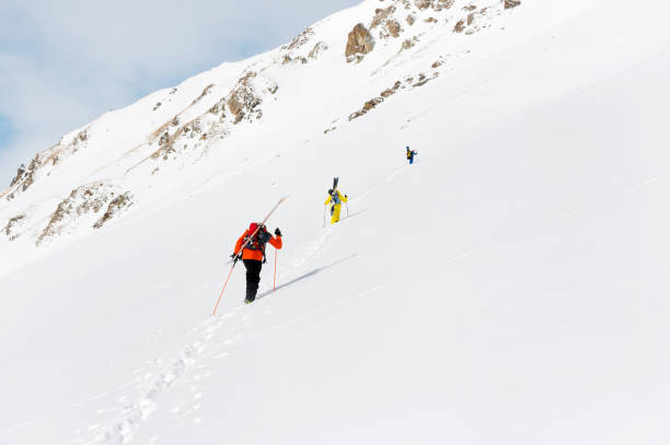 istock two ski freerider climbs the slope into deep snow powder with the equipment on the back fixed on the backpack 915830834