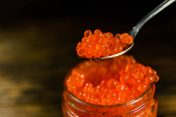 istock Red caviar in a spoon above the glass jar 915839826