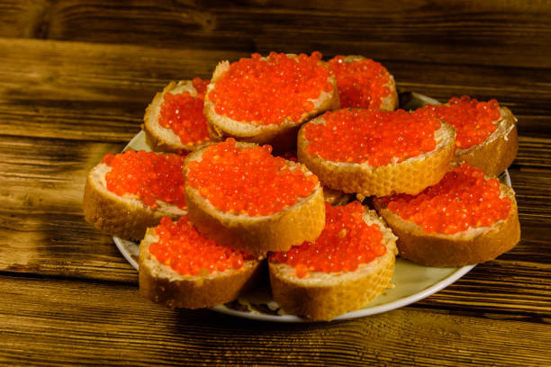 istock Sandwiches with red caviar on wooden table 915839854