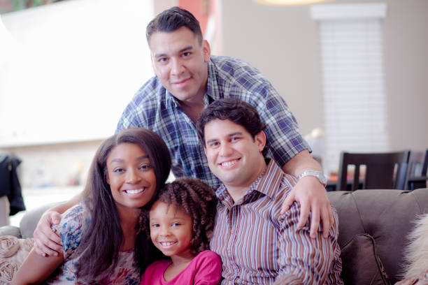 istock Multi ethnic family at home on couch playing with daughter. 915842632