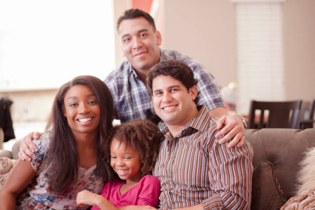 istock Multi ethnic family at home on couch playing with daughter. 915842636