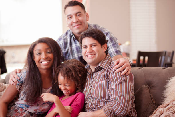 istock Multi ethnic family at home on couch playing with daughter. 915842690