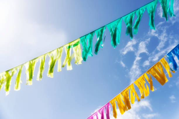 istock Carnival decoration - colored paper stripes under a clear sky 915843420